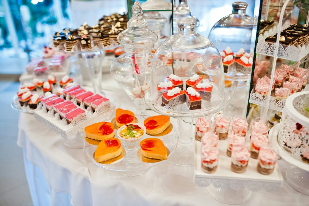 Different sweets and cupcakes at catering wedding reception table.