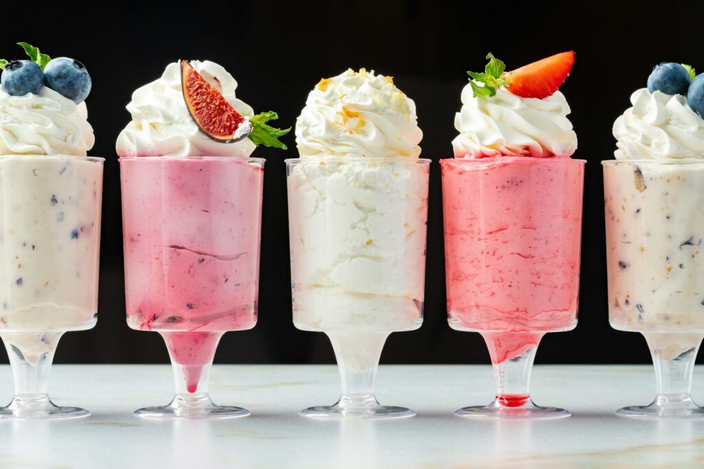 Large collection of mousse desserts in glasses for catering