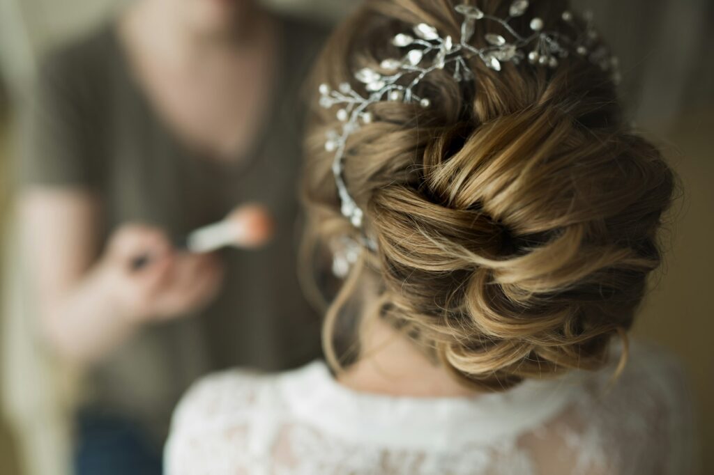 makeup artist preparing bride before the wedding in a morning